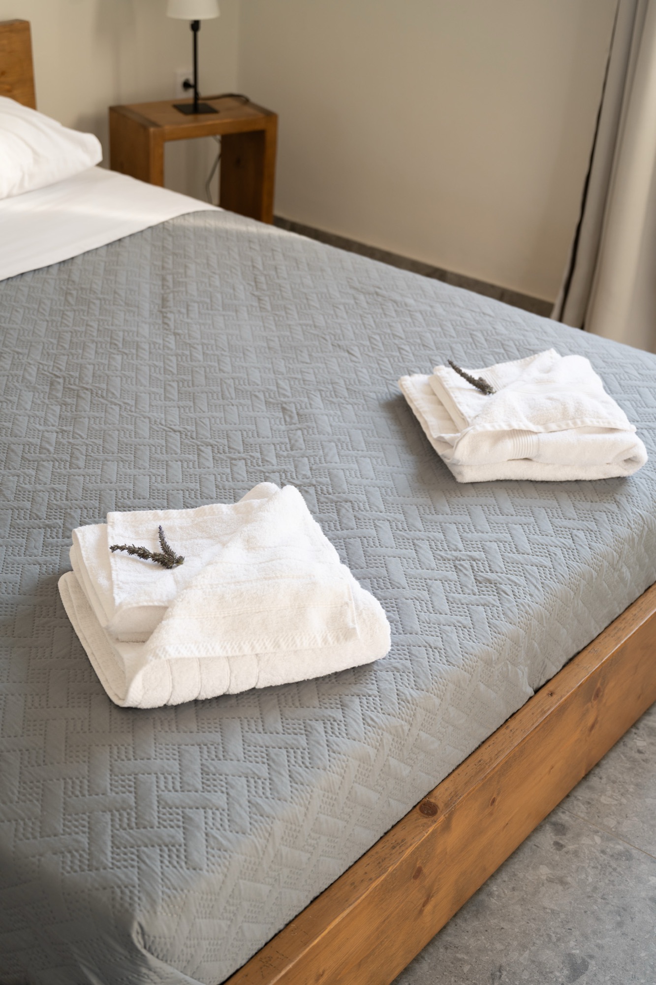 Folded towels and fresh linen on the bed
