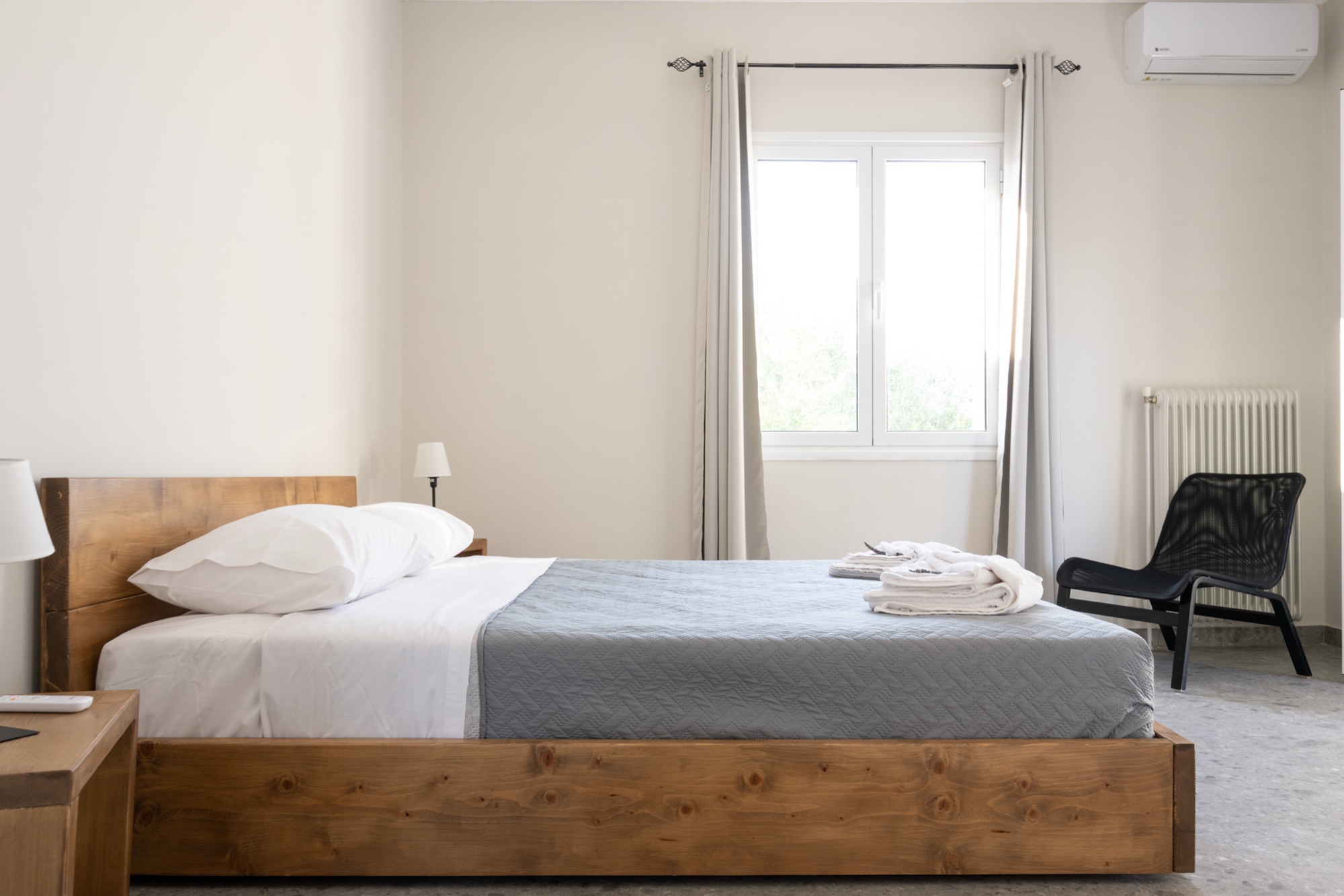 Main bedroom with wooden bed frame and air conditioning